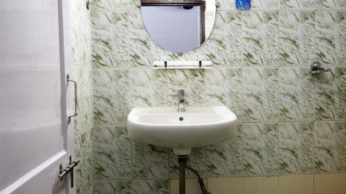 a bathroom with a sink and a mirror on the wall at Shelter Guest House in Candolim