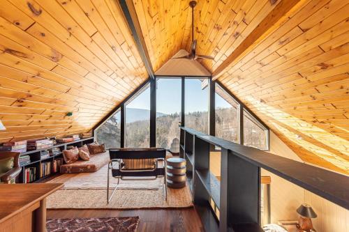 a room with a large wooden ceiling with windows at The Bellows House - Views Deck Skiing in Fleischmanns
