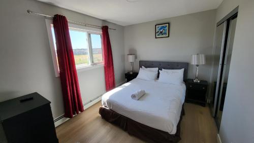 a bedroom with a white bed with red curtains at Heavenly Rest by JC in Edmonton
