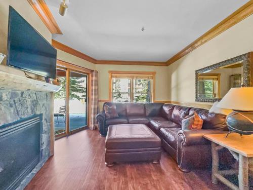 a living room with a leather couch and a fireplace at CS129 Copper Springs in Copper Mountain