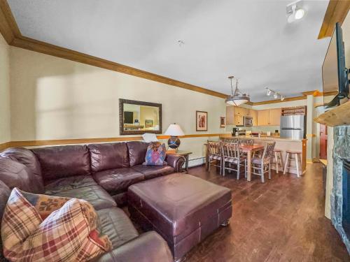 a living room with a brown couch and a kitchen at CS129 Copper Springs in Copper Mountain