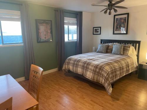 a bedroom with a bed and a ceiling fan at Bayside Inn in Alert Bay
