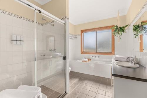 a bathroom with a shower and a tub and a sink at Three Acres, Barossa Valley in Williamstown