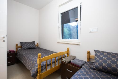 a bedroom with a bed and a window at Villa Eterna in Tarčin