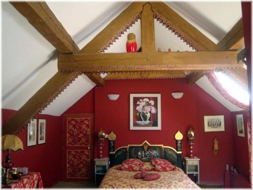 La Becassiere في Thorenc: غرفة نوم بجدران حمراء وسرير في غرفة