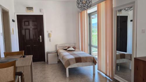 a small bedroom with a bed and a window at Студио JASMIN in Tsarevo