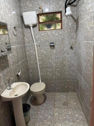 a bathroom with a toilet and a sink at Casa Beira Rio in Araras