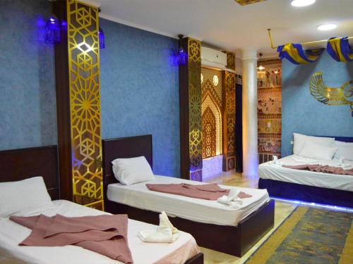 a room with two beds in it with blue walls at Comfort Pyramids Inn in Cairo