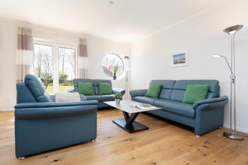 a living room with two blue couches and a table at Reiterhof Rickert Glücksklee in Meeschendorf