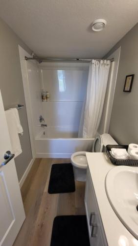 a bathroom with a tub and a toilet and a sink at Heavenly Rest by JC in Edmonton