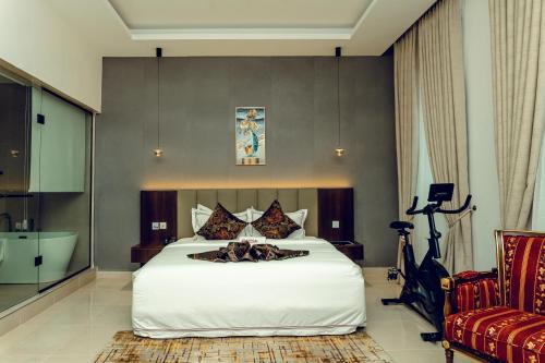 a bedroom with a large white bed and a bathroom at Treal Hotels & Suites in Abeokuta