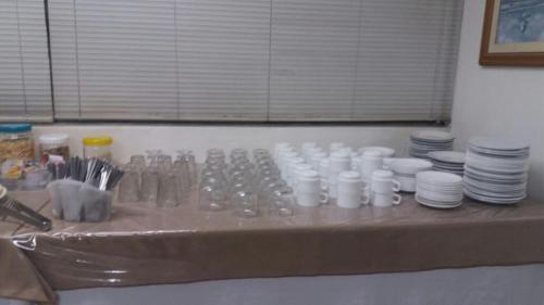 a table with plates and utensils on top at Uniflat Hotel Bauru in Bauru