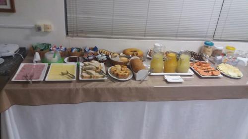 a table with a buffet of food on it at Uniflat Hotel Bauru in Bauru