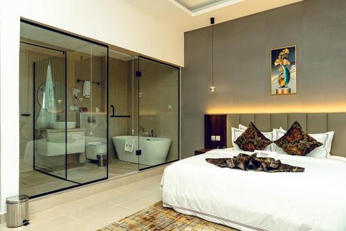 a bedroom with a large bed and a bathroom at Treal Hotels & Suites in Abeokuta