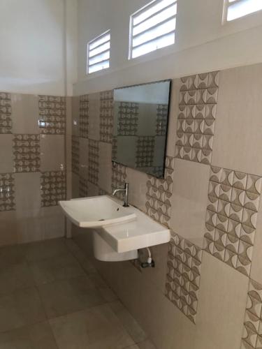 a bathroom with a sink and a mirror at Athena Guest House in Trincomalee