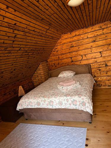 a bedroom with a bed in a wooden cabin at Vikendica Lenka in Sijarinska Banja