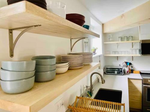 a kitchen with bowls and plates on a shelf at The Bunker - Ski Shuttle Shopping Center in Stowe