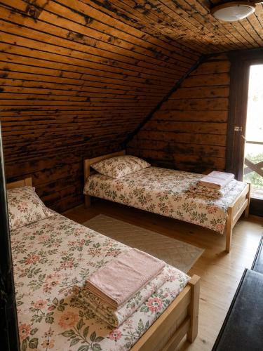 a room with two beds in a log cabin at Vikendica Lenka in Sijarinska Banja