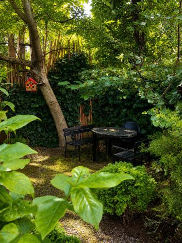 a picnic table and a bench in a garden at Guest House Germani in Telavi