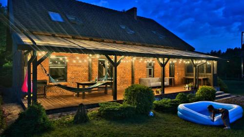 a house with a hammock on a deck at night at Siedlisko Drwęck in Drwęck