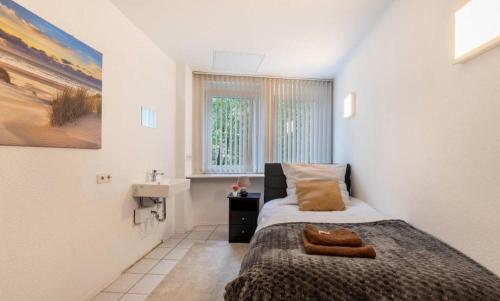 a small bedroom with a bed and a sink at Relax Apartment Backnang in Backnang