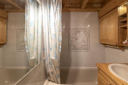 a bathroom with a tub and a sink at 6 pers, proche pistes et commerces in Morillon
