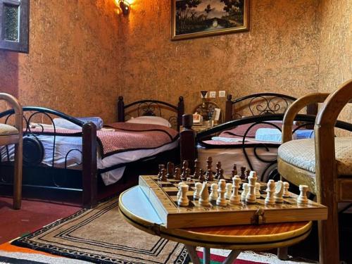 a room with a chessboard and a room with beds at Riad Espace Asrir Tiznit in Tiznit