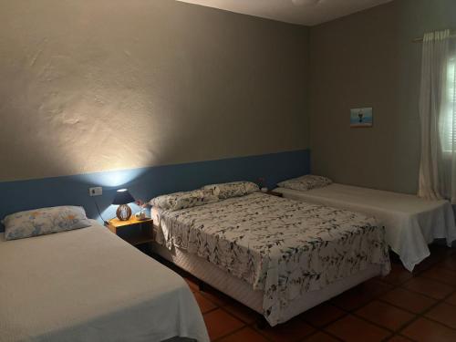 a hotel room with two beds and a window at Villa Dona Jaca - Casa da Mata - 01 in Socorro