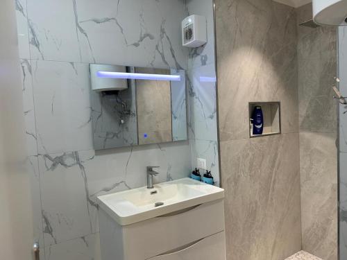 a white bathroom with a sink and a mirror at Xhani Boutique Rooms in Durrës