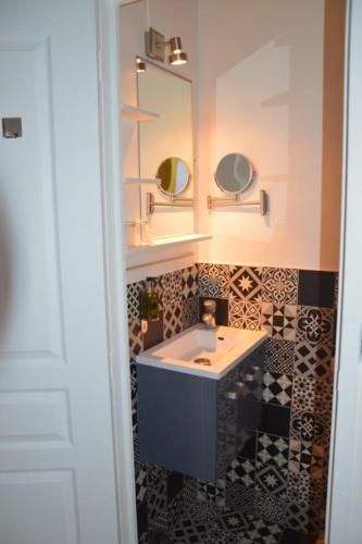 a bathroom with a sink and a mirror at Hotel Castellamar in Sainte-Maxime