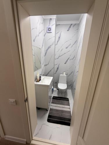 a bathroom with a white toilet and a sink at Берег3 in Bosteri