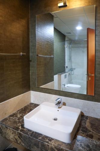 a bathroom with a white sink and a mirror at MGM Service Apartment by Savills Oman in Muscat