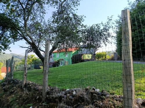 a fence in front of a field with a tree at Casa en CEDEIRA in Cedeira
