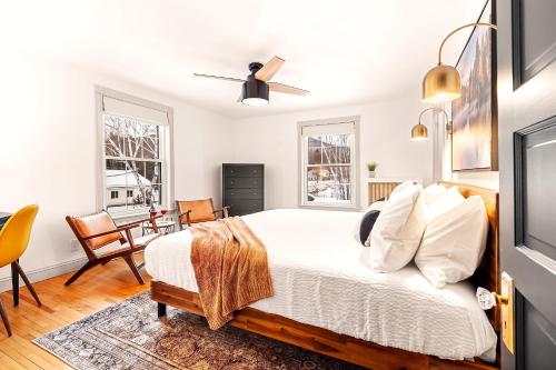 a bedroom with a bed and two windows at Launchpoint Lodge in Lincoln