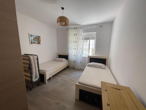 a small room with two beds and a window at Mateo Apartment in Himare