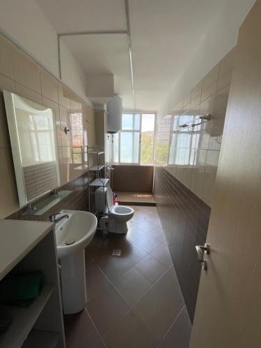 a bathroom with a toilet and a sink and a mirror at Mateo Apartment in Himare