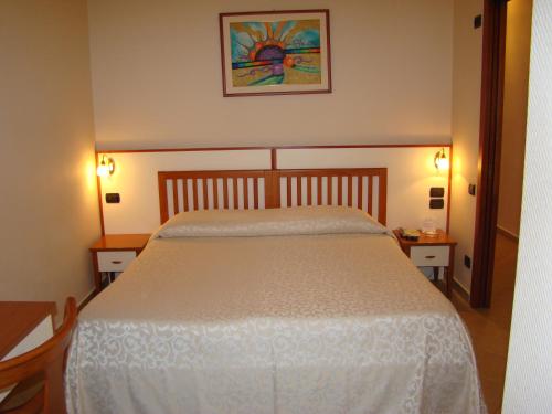 a bedroom with a large white bed with two tables at Hotel Residence Due Mari in Marcellinara