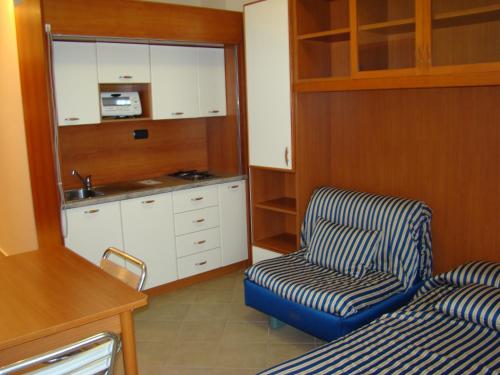a living room with a chair and a kitchen at Hotel Residence Due Mari in Marcellinara