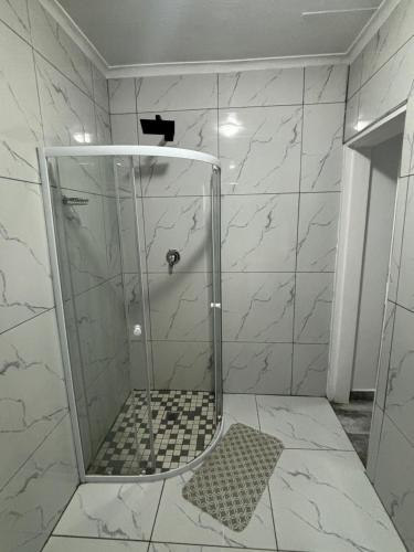 a shower with a glass door in a bathroom at Randhart guesthouse in Alberton
