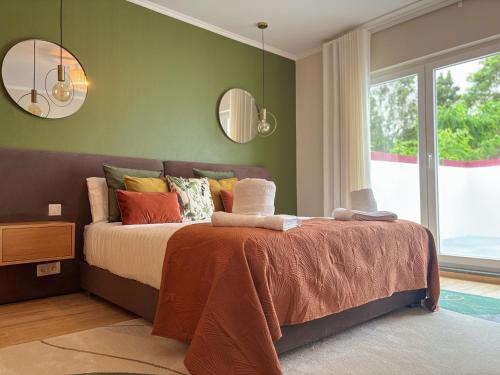 a bedroom with a bed and two mirrors on the wall at Chalé d'Angra Guest House in Angra do Heroísmo