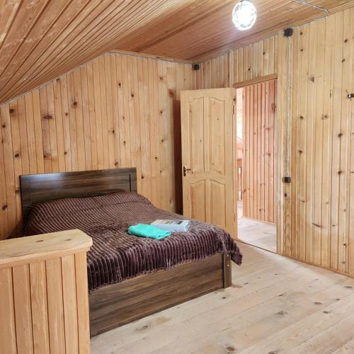 a bedroom with a bed in a wooden cabin at Сабудара in Martvili