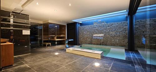 a swimming pool in a room with a brick wall at Beleza in La Salle-les-Alpes