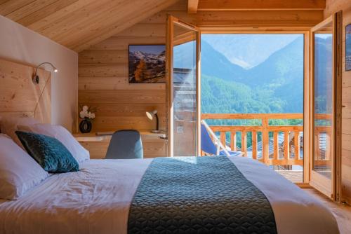 a bedroom with a bed and a large window at Aigle in Le Monêtier-les-Bains