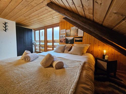 a bedroom with a large bed with towels on it at Acolin in Briançon
