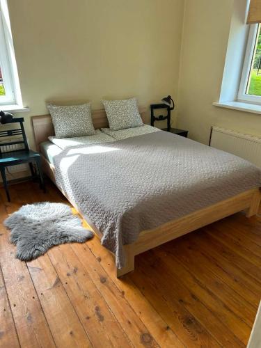 a large bed in a room with a wooden floor at Baumanis klasika in Valmiera