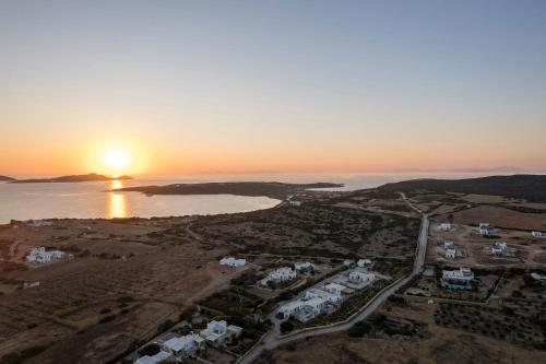 an aerial view of a city with the sunset at Noble Pearl Villas Paros in Santa Maria