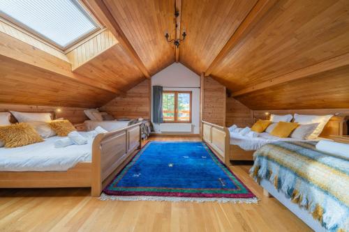 two beds in a room with wooden ceilings at Le Stam in La Salle-les-Alpes