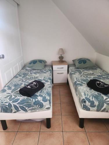 two beds sitting next to each other in a room at Ti Coco Luce family à Sainte Luce dans village de vacances in Sainte-Luce