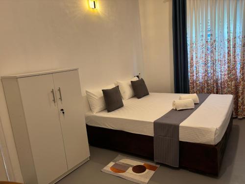 a bedroom with a large bed and a window at The Cottage Weligama in Weligama