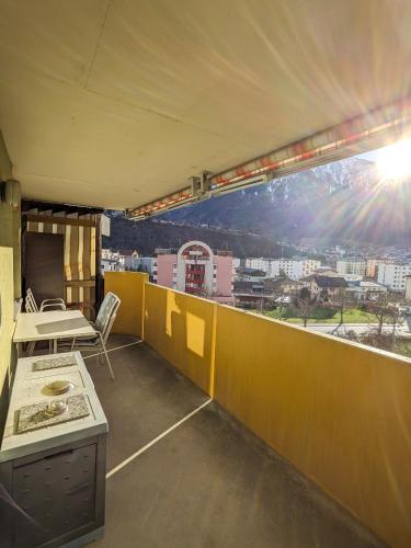 a room with a balcony with a view of a city at Apartment Above the Rooftops - Mountain Panorama in Naters